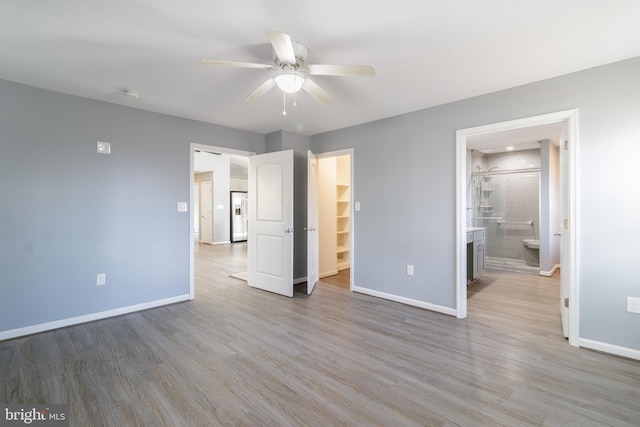 87 Tulip Poplar Dr, Linden, VA 22642 - unfurnished bedroom featuring baseboards, light wood-style flooring, a walk in closet, ensuite bath, and a ceiling fan