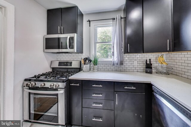 5016 56th Ave, Hyattsville, MD 20781 - kitchen featuring appliances with stainless steel finishes, decorative backsplash, and dark cabinets