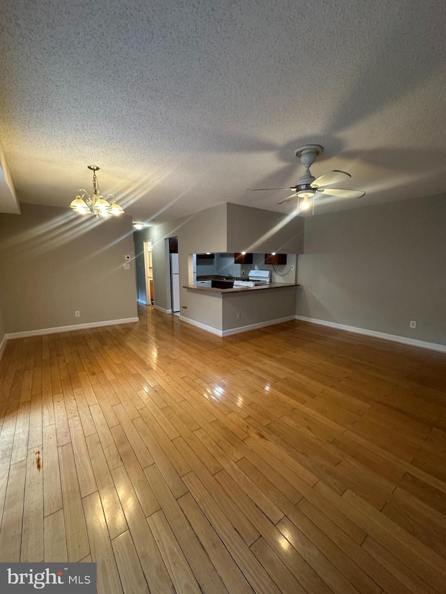7980 Audubon Ave Unit C3, Alexandria, VA 22306 - unfurnished living room featuring a chandelier, a ceiling fan, baseboards, a textured ceiling, and vaulted ceiling