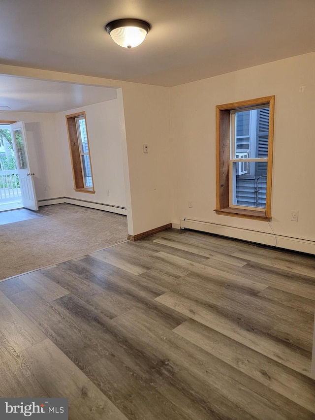 128 W Main St, New Bloomfield, PA 17068 - empty room with wood finished floors, baseboard heating, baseboards, and a baseboard heating unit