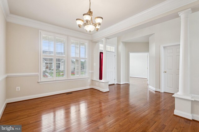 24 Tocati St, Thurmont, MD 21788 - empty room featuring ornate columns, wood finished floors, ornamental molding, and a chandelier