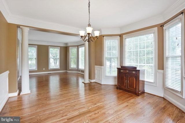 5438 Sherman Oaks Ct, Haymarket, VA 20169 - unfurnished dining area with light wood-type flooring, a chandelier, decorative columns, crown molding, and a wainscoted wall