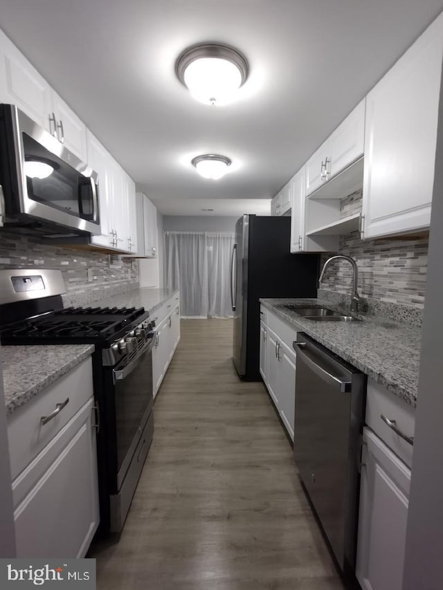 2573 Paxton St, Woodbridge, VA 22192 - kitchen featuring appliances with stainless steel finishes, a sink, tasteful backsplash, and white cabinetry