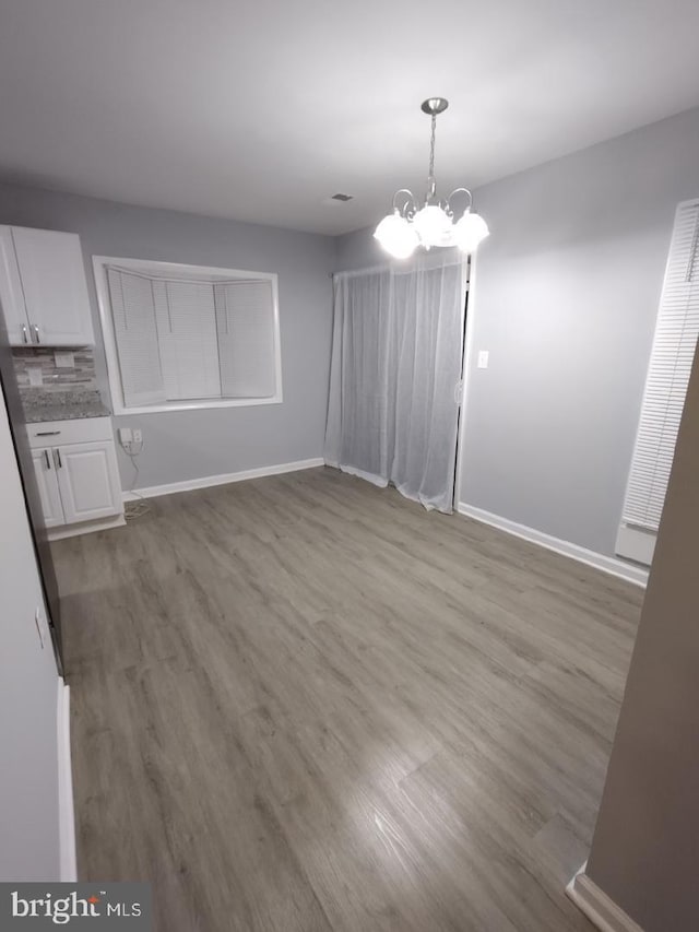 2573 Paxton St, Woodbridge, VA 22192 - unfurnished dining area with wood finished floors, baseboards, and a chandelier