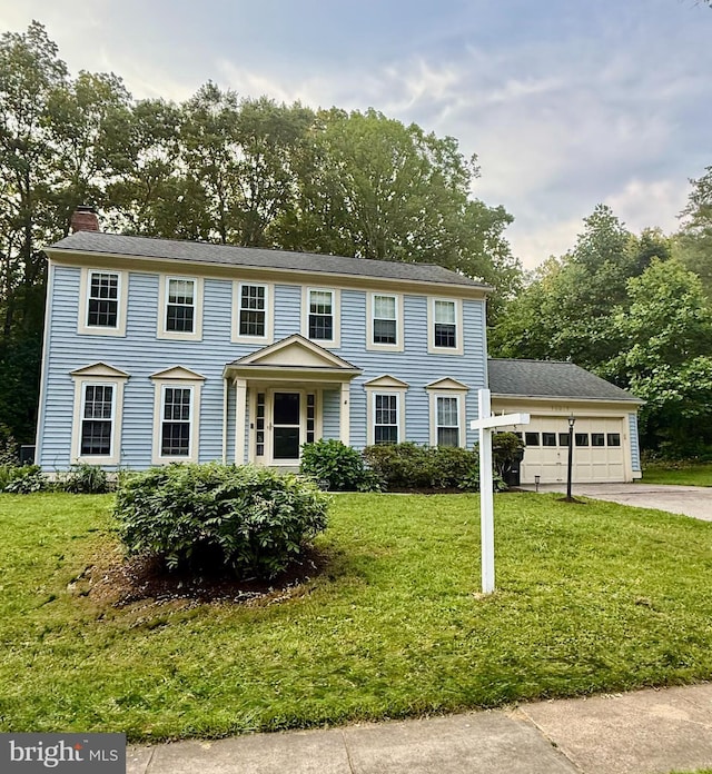 15871 Montview Dr, Dumfries, VA 22025 - colonial home featuring a chimney, concrete driveway, a front yard, and an attached garage