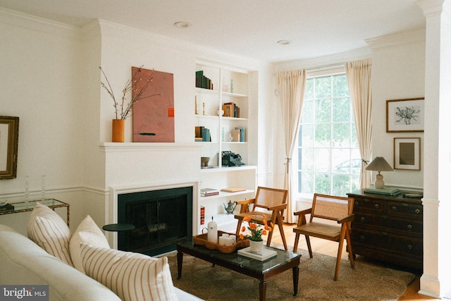 708 9th St SE, Washington, DC 20003 - living room featuring built in shelves, ornamental molding, a fireplace, and wood finished floors