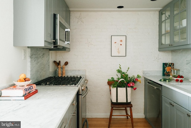 708 9th St SE, Washington, DC 20003 - kitchen featuring appliances with stainless steel finishes, light countertops, light wood finished floors, baseboards, and glass insert cabinets