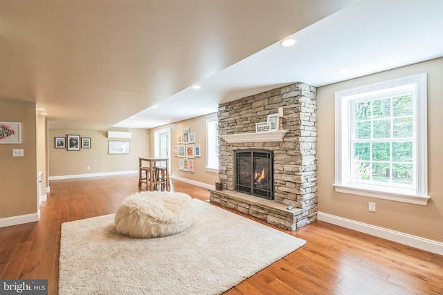 1337 Pennsridge Pl, Downingtown, PA 19335 - living area with wood finished floors, a stone fireplace, baseboards, and a wall mounted air conditioner