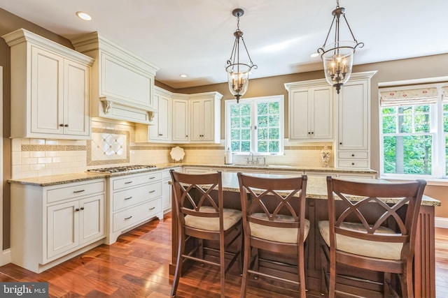 1337 Pennsridge Pl, Downingtown, PA 19335 - kitchen featuring gas stovetop, dark wood-type flooring, decorative light fixtures, tasteful backsplash, and light stone counters