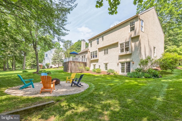 1337 Pennsridge Pl, Downingtown, PA 19335 - rear view of property featuring an outdoor fire pit, a lawn, stucco siding, and a chimney