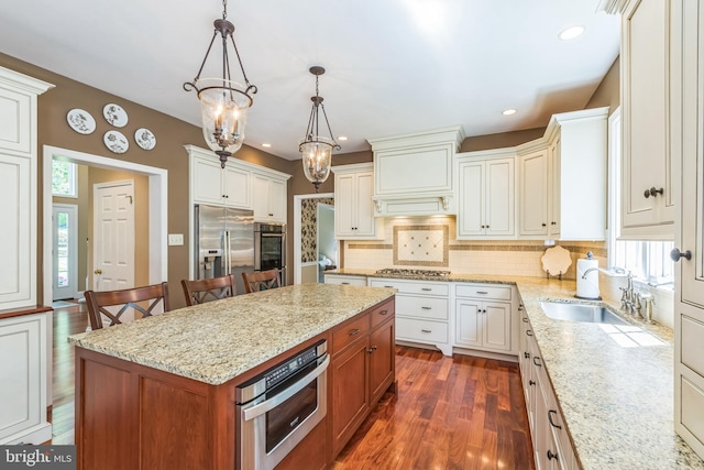 1337 Pennsridge Pl, Downingtown, PA 19335 - kitchen featuring stainless steel appliances, dark wood-type flooring, decorative backsplash, a kitchen island, and light stone counters