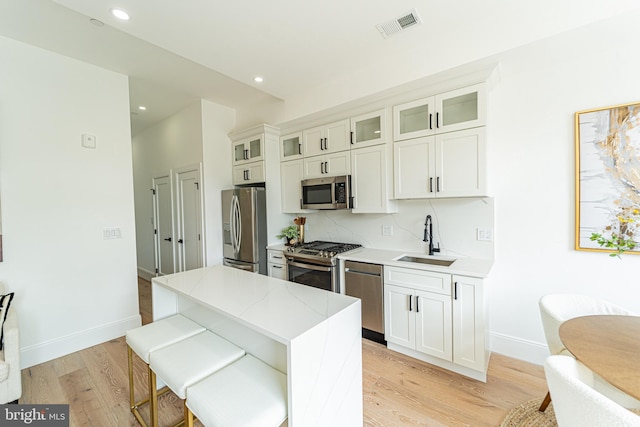 2517 Ontario Rd NW Unit Ph8, Washington, DC 20009 - kitchen with stainless steel appliances, a sink, a center island, light wood-type flooring, and recessed lighting