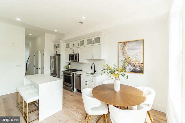 2517 Ontario Rd NW Unit Ph8, Washington, DC 20009 - kitchen with stainless steel appliances, a sink, light countertops, recessed lighting, and light wood-style floors
