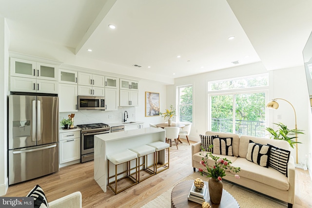 2517 Ontario Rd NW Unit Ph8, Washington, DC 20009 - kitchen featuring appliances with stainless steel finishes, a sink, a kitchen island, light wood-style flooring, and light countertops
