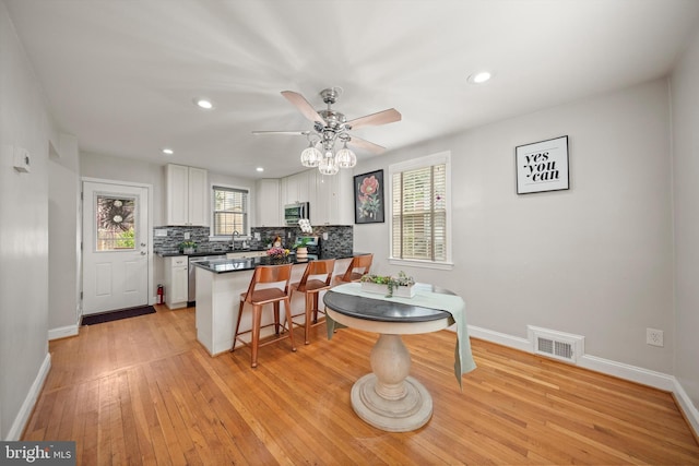 10004 Lorain Ave, Silver Spring, MD 20901 - kitchen featuring white cabinets, appliances with stainless steel finishes, a ceiling fan, a peninsula, and baseboards