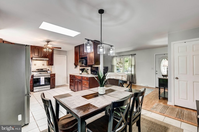680 Geneva Dr, Westminster, MD 21157 - dining room featuring light tile patterned floors, a skylight, and a ceiling fan