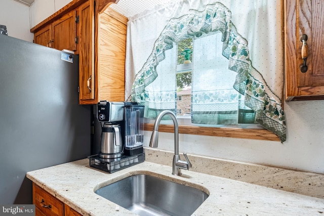 225 E State St, Coopersburg, PA 18036 - kitchen featuring freestanding refrigerator, brown cabinets, a sink, and light stone countertops