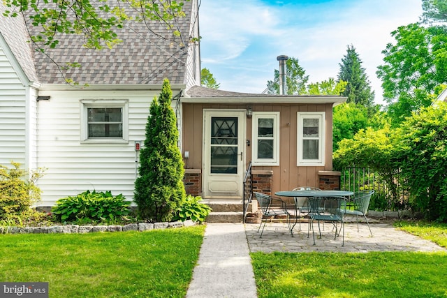 225 E State St, Coopersburg, PA 18036 - view of exterior entry featuring roof with shingles, a patio, a lawn, and board and batten siding