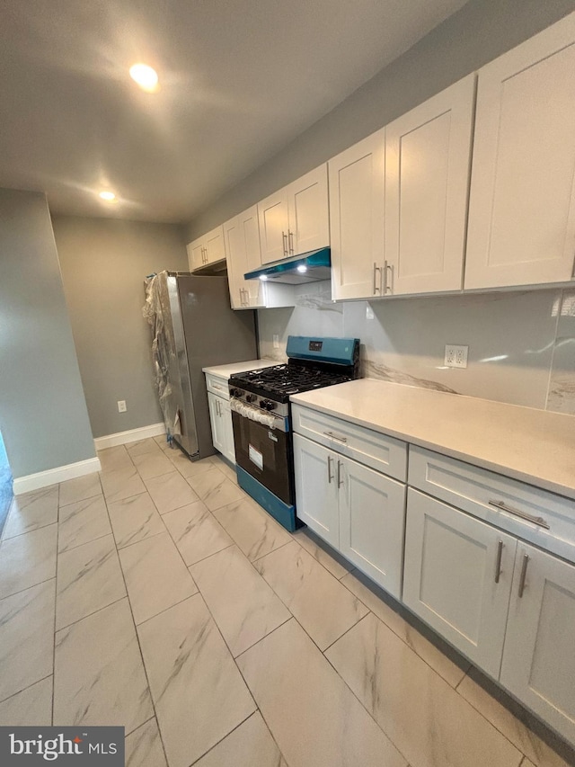 6226 Cardiff St, Philadelphia, PA 19149 - kitchen with range with gas stovetop, under cabinet range hood, light marble finish floors, baseboards, and light countertops