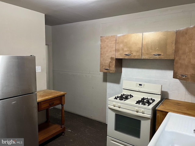 5224 Florence Ave, Philadelphia, PA 19143 - kitchen with freestanding refrigerator, white gas stove, wood counters, concrete flooring, and a sink
