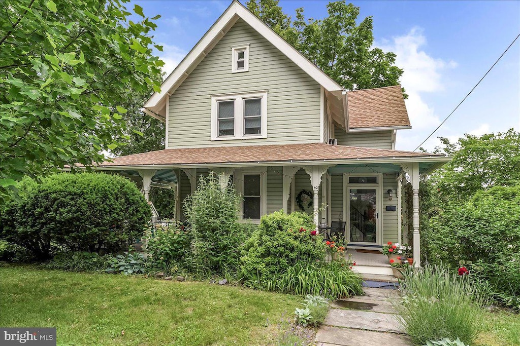 42 Linden Ave, Rutledge, PA 19070 - view of front of home with covered porch, a shingled roof, and a front lawn