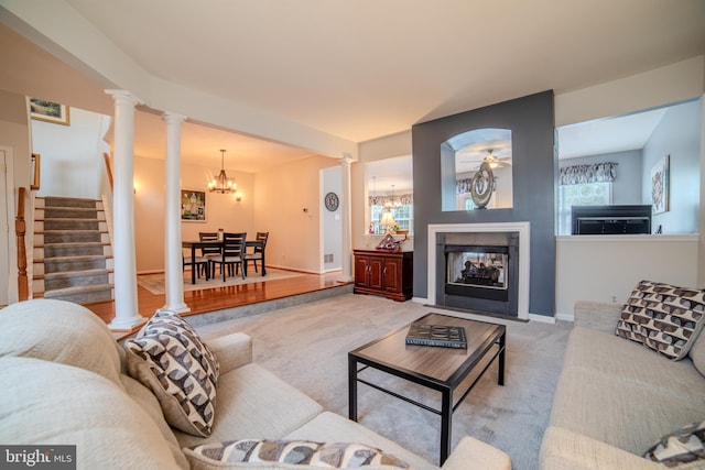 854 Hinchley Run, West Chester, PA 19382 - carpeted living room featuring a chandelier, decorative columns, a multi sided fireplace, and stairs