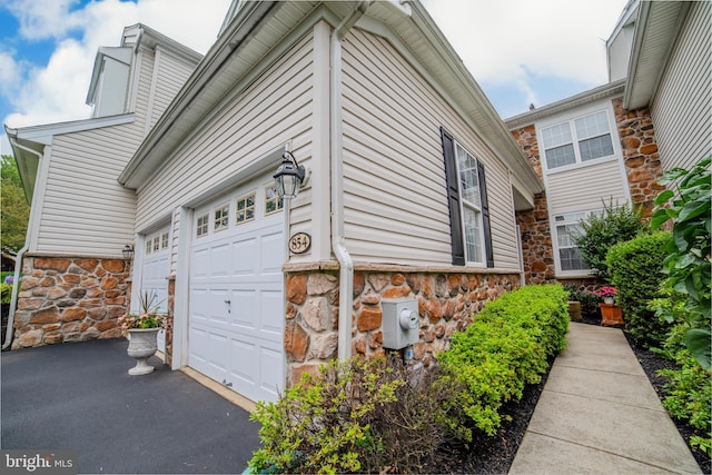 854 Hinchley Run, West Chester, PA 19382 - view of side of property featuring stone siding, driveway, and a garage