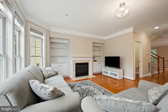 9769 June Flowers Way, Laurel, MD 20723 - living room featuring ornamental molding, stairway, wood finished floors, a fireplace with flush hearth, and built in features