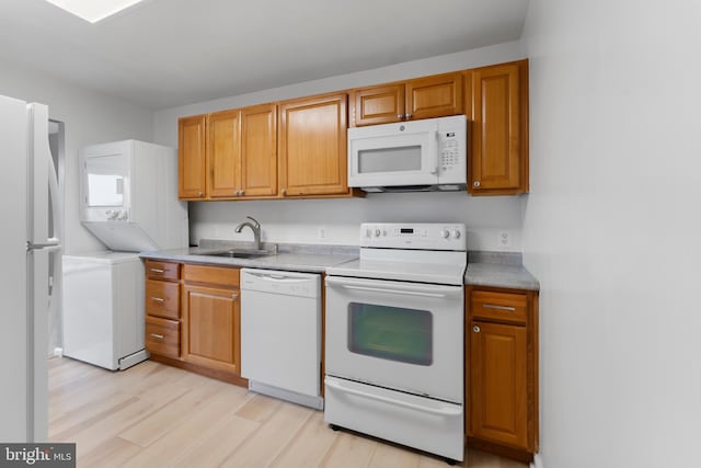 12001 Old Columbia Pike Unit 709, Silver Spring, MD 20904 - kitchen featuring white appliances, a sink, light wood-style floors, light countertops, and brown cabinetry