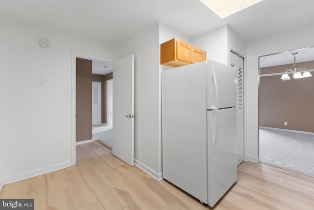 12001 Old Columbia Pike Unit 709, Silver Spring, MD 20904 - kitchen featuring freestanding refrigerator, light wood finished floors, a chandelier, and baseboards