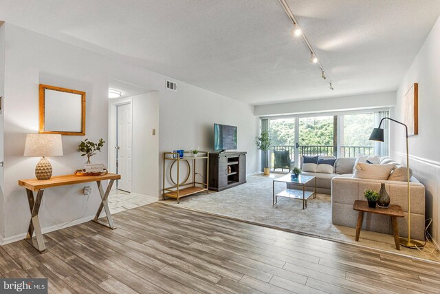 1300 Army Navy Dr S Unit 227, Arlington, VA 22202 - living area with wood finished floors, track lighting, a textured ceiling, and a fireplace