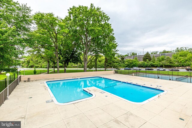 1300 Army Navy Dr S Unit 227, Arlington, VA 22202 - community pool featuring a patio area and view of wooded area