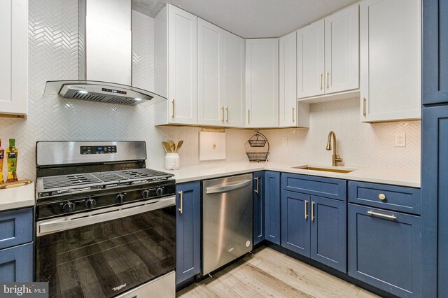 1300 Army Navy Dr S Unit 227, Arlington, VA 22202 - kitchen with stainless steel appliances, wall chimney range hood, blue cabinetry, light wood finished floors, and white cabinetry