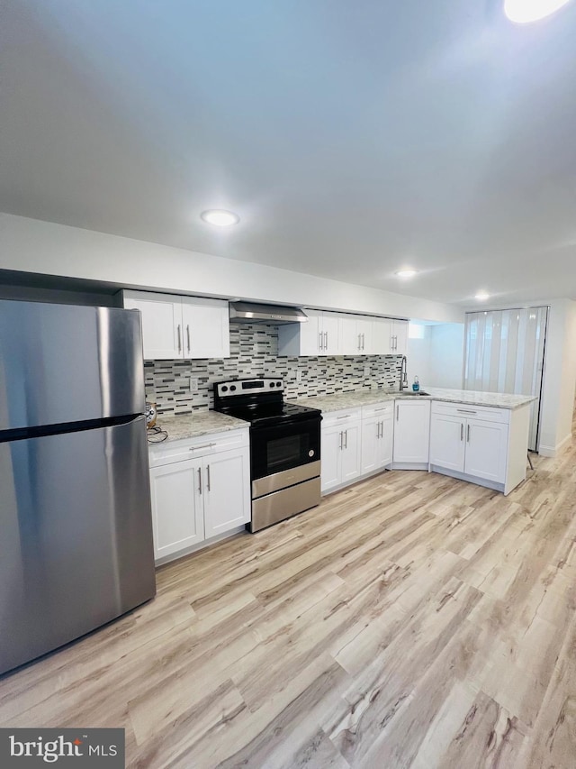 2303 Oakmont St, Philadelphia, PA 19152 - kitchen with appliances with stainless steel finishes, wall chimney exhaust hood, white cabinetry, decorative backsplash, and light wood finished floors