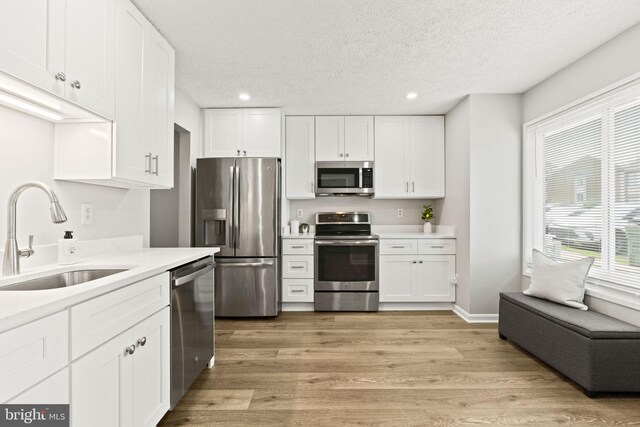 2825 Cambridge Dr, Woodbridge, VA 22192 - kitchen with appliances with stainless steel finishes, a textured ceiling, white cabinets, recessed lighting, and light countertops