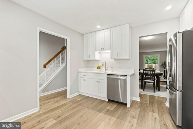 2825 Cambridge Dr, Woodbridge, VA 22192 - kitchen with appliances with stainless steel finishes, white cabinetry, light countertops, light wood-style flooring, and recessed lighting
