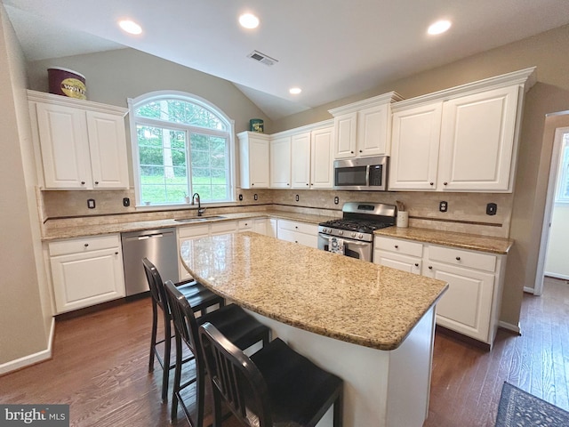 25 Baldwin Cir, Glenmoore, PA 19343 - kitchen with stainless steel appliances, lofted ceiling, white cabinetry, a kitchen island, and tasteful backsplash