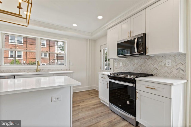 464 Fairfield Rd, Plymouth Meeting, PA 19462 - kitchen with stainless steel gas range oven, crown molding, light wood-style flooring, decorative backsplash, and white cabinetry