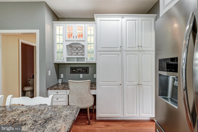 66 Light Farm Dr, Cochranville, PA 19330 - kitchen with stainless steel fridge with ice dispenser, light wood-type flooring, dark stone countertops, white cabinets, and glass insert cabinets