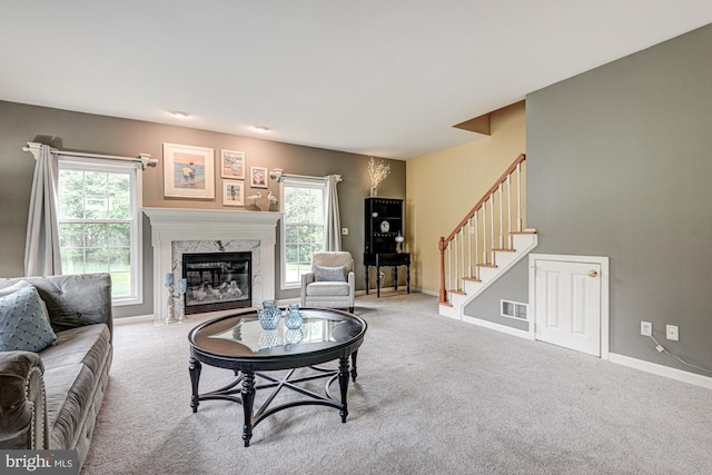 66 Light Farm Dr, Cochranville, PA 19330 - carpeted living room featuring a fireplace, stairs, and plenty of natural light