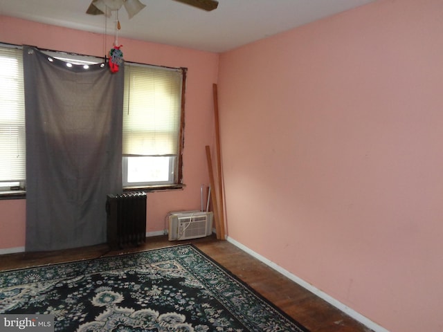 4636 Kraydor St, Philadelphia, PA 19136 - spare room featuring radiator, ceiling fan, baseboards, dark wood-type flooring, and a wall mounted air conditioner