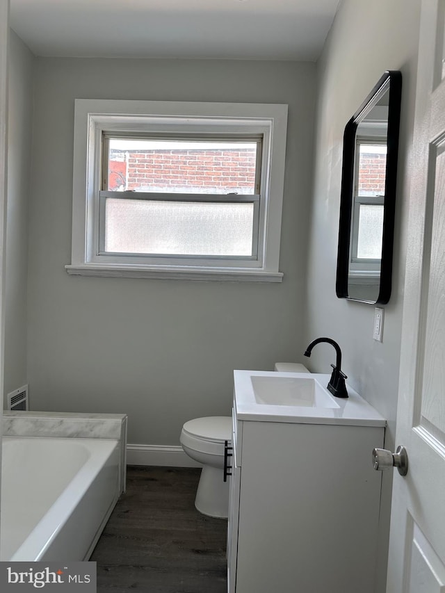 5235 Baltimore Ave, Philadelphia, PA 19143 - full bath with vanity, toilet, wood finished floors, a tub to relax in, and baseboards