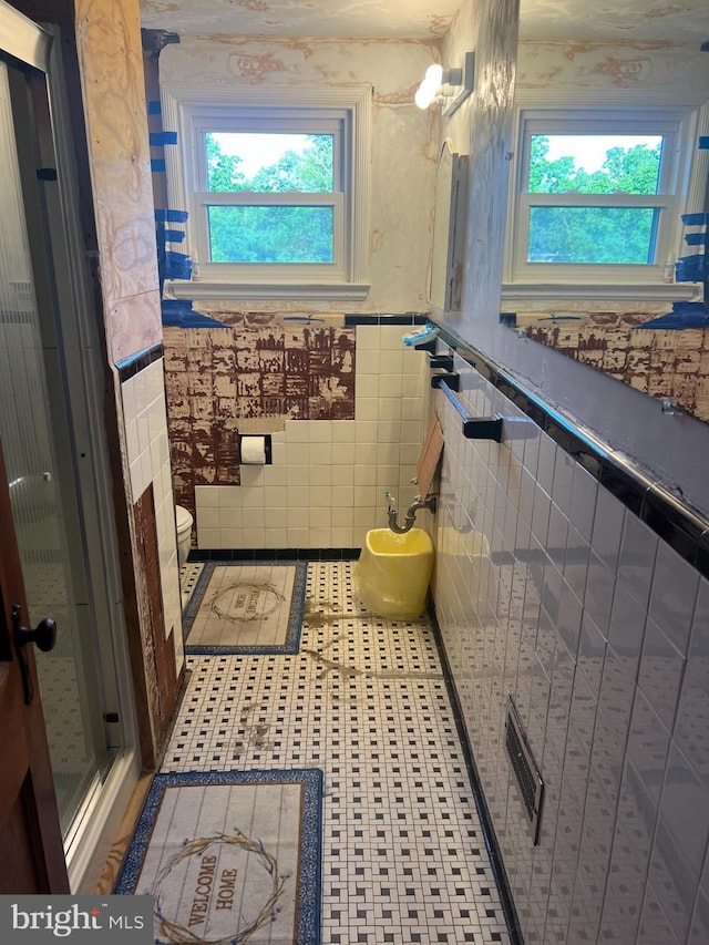 1969 Victory Dr, Baltimore, MD 21227 - bathroom with toilet, tile walls, and a wainscoted wall