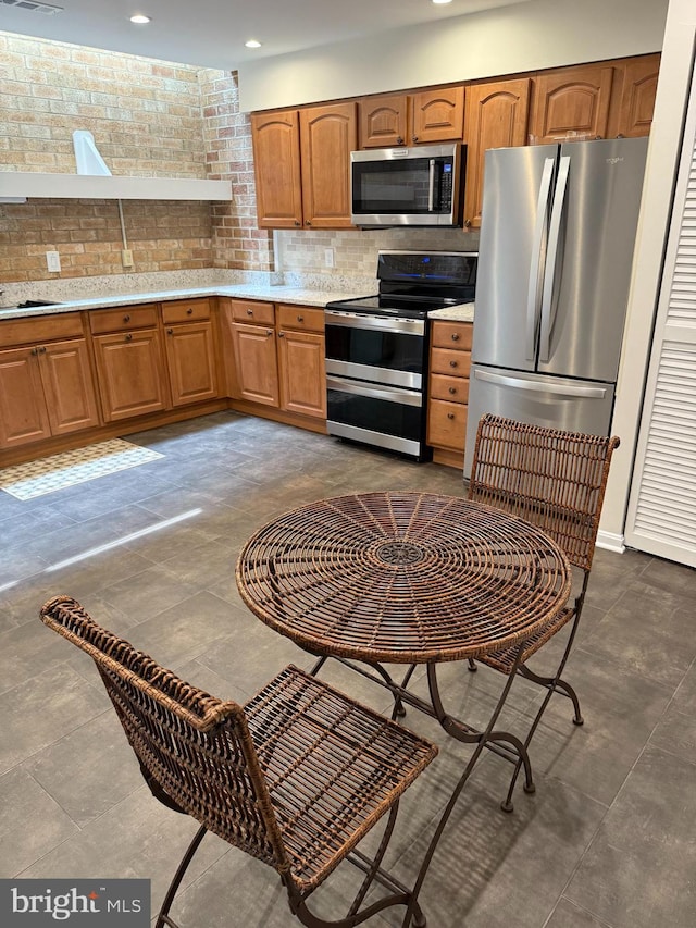 5147 Dudley Ln Unit 44, Bethesda, MD 20814 - kitchen featuring appliances with stainless steel finishes, light countertops, brown cabinetry, decorative backsplash, and recessed lighting