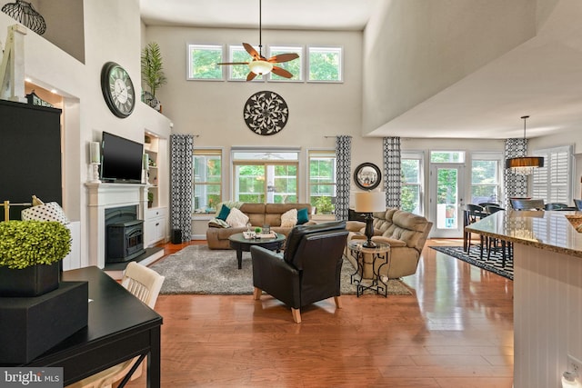 11742 Maid At Arms Ln, Berlin, MD 21811 - living area featuring a ceiling fan, light wood-style flooring, a fireplace with raised hearth, and a high ceiling