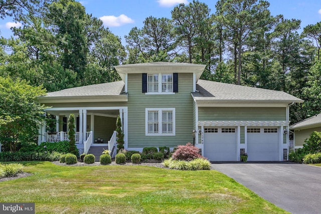 11742 Maid At Arms Ln, Berlin, MD 21811 - view of front of house featuring a garage, a front lawn, driveway, covered porch, and a shingled roof