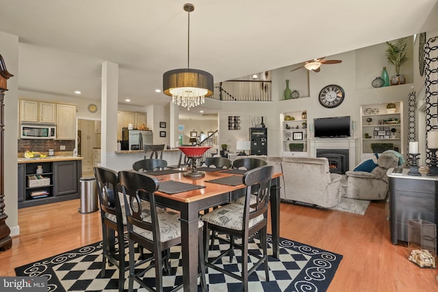 11742 Maid At Arms Ln, Berlin, MD 21811 - dining area featuring a ceiling fan, light wood finished floors, built in shelves, a lit fireplace, and recessed lighting