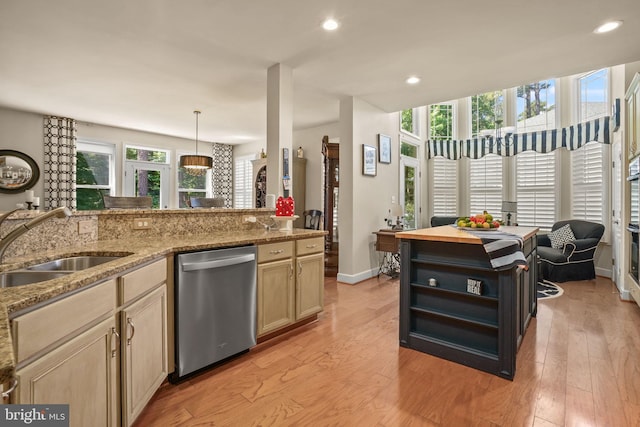 11742 Maid At Arms Ln, Berlin, MD 21811 - kitchen featuring dishwasher, a sink, light wood-style flooring, baseboards, and light stone countertops