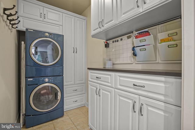 11742 Maid At Arms Ln, Berlin, MD 21811 - laundry room with estacked washer and dryer, cabinet space, and light tile patterned flooring
