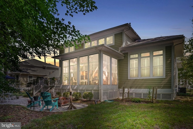 11742 Maid At Arms Ln, Berlin, MD 21811 - back of property at dusk featuring a sunroom, a yard, and a patio area